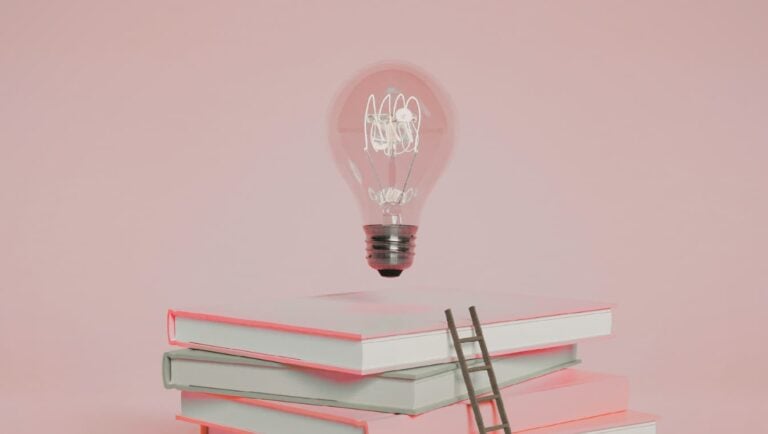 image of lightbulb above a stack of books